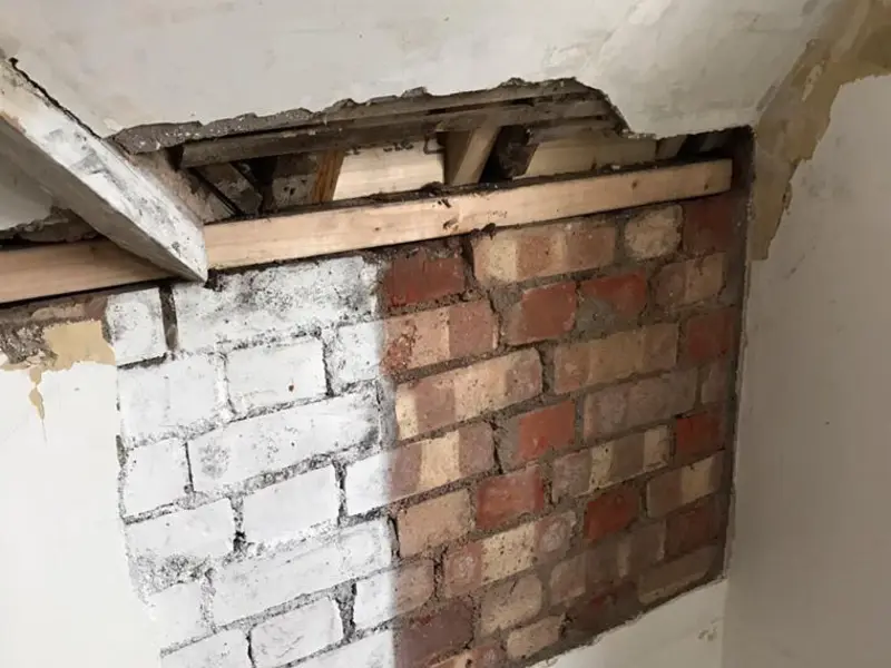 Rising damp on internal wall before damp proofing treatment by City Building and Roofing Ltd